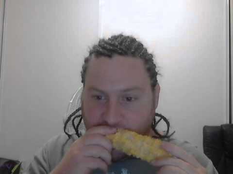 Guy with cornrows eats corn while listening to korn